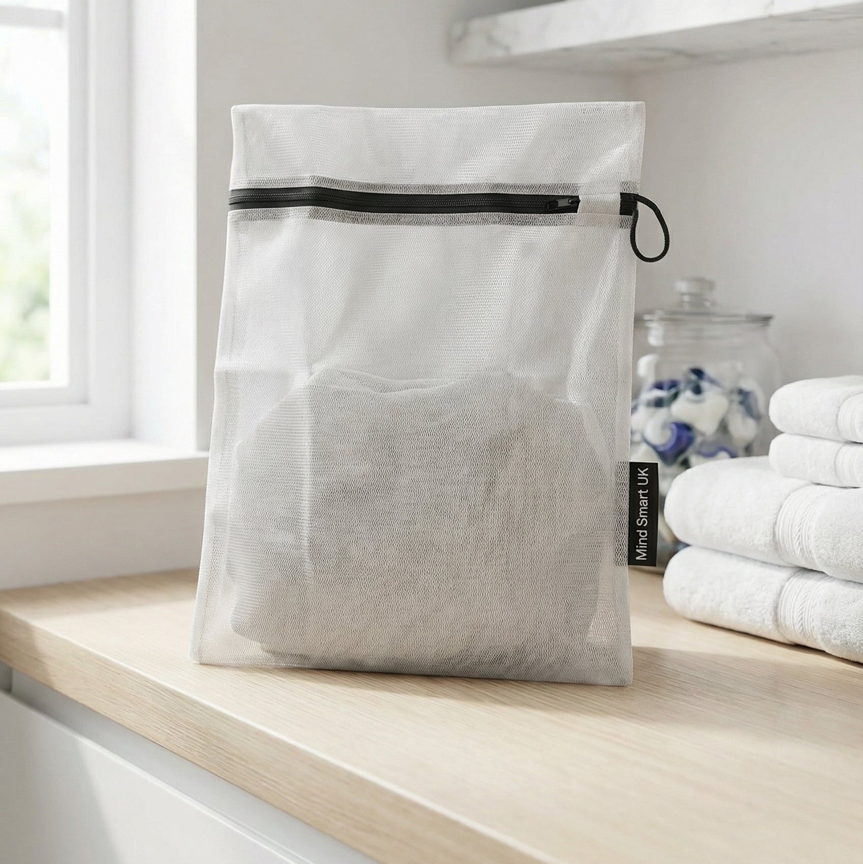 Mind Smart UK white laundry bag with black zipper on a wooden worktop